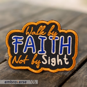 May include: A black and orange embroidered patch with the text "Walk by Faith Not by Sight" in white and blue lettering.