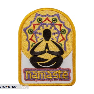 May include: Embroidered patch with a yellow background and a purple mandala design. A black figure is sitting in a lotus position with hands in prayer position. The text "namaste" is embroidered in purple on a white background.