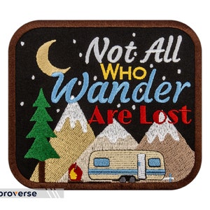May include: Embroidered patch with a black background, a crescent moon, a pine tree, mountains, a campfire, and a camper. The text reads "Not All Who Wander Are Lost".