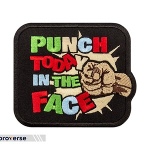 Pode incluir: Etiqueta bordada preta com um punho socando para frente e o texto "Punch Today In The Face" em letras coloridas.