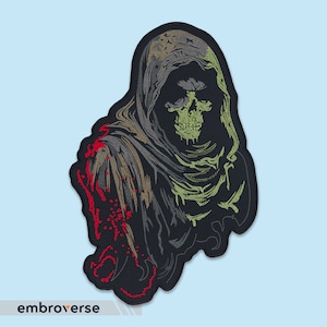 May include: Embroidered patch depicting a hooded figure with a skull face, in shades of green, black, and red. The figure is wearing a hooded cloak and has a menacing expression.