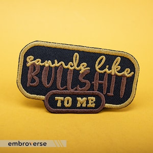 May include: A black embroidered patch with gold stitching. The patch says "Sounds like bullshit to me".