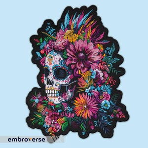 Op de afbeelding: Een kleurrijk geborduurd patch met een suiker schedel met een bloemenkrans. De schedel is wit met zwarte contouren en kleurrijke details. De bloemen zijn roze, paars, geel en blauw.