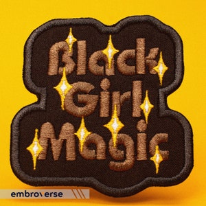 May include: Brown embroidered patch with the text "Black Girl Magic" in a retro font. The patch is surrounded by a black border and features yellow and white glitter accents.