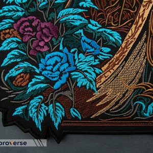Puede incluir: Parche bordado con un dise&ntilde;o floral con flores azules, moradas y marrones sobre un fondo negro.