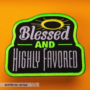 May include: A black and green embroidered patch with a yellow sun and the text "Blessed and Highly Favored" in white.