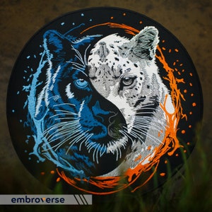 Peut inclure: Patch brodé représentant un panthère noire et un léopard des neiges blanc, leurs visages entrelacés dans un design yin yang. L'arrière-plan est noir avec des tourbillons orange et bleus.