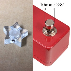 May include: A clear, star-shaped guitar pedal knob next to a red guitar pedal with a silver button. The button is 3/8 inch (10mm) in diameter.