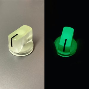 以下が含まれることがあります： 黒い線が引かれた白いプラスチック製のノブ。ノブは暗闇で緑色に光ります。