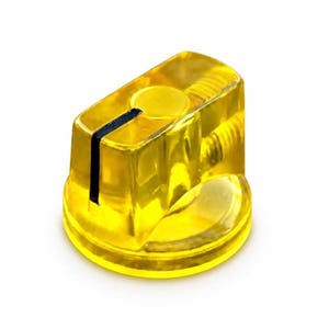 May include: A translucent yellow plastic control knob with a cylindrical base and a rectangular top section. A single black vertical line is printed on the side of the knob to indicate position. The interior structure shows a threaded metal insert.