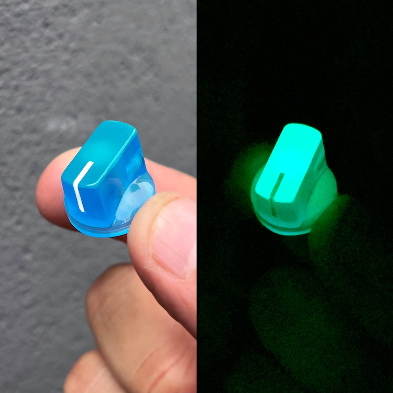 Puede incluir: Una perilla azul claro con una l&iacute;nea blanca en el centro. La perilla brilla en verde en la oscuridad.