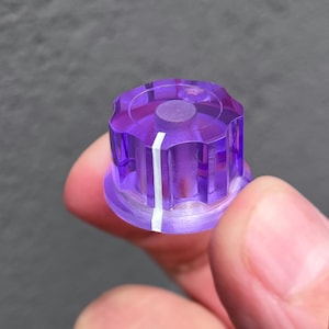 May include: Purple plastic knob with a white line down the center. The knob has a textured surface and is designed for use with electronic equipment.