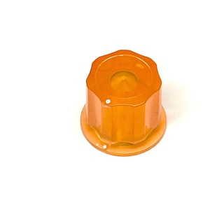 May include: An orange, octagonal knob with a circular top and a small white dot. The knob has a rounded base, set against a white background. The object is likely a control knob.
