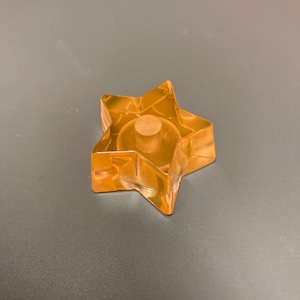 Peut inclure: Un bouchon de bouteille en forme d'étoile transparente avec un dessus rond en bois.