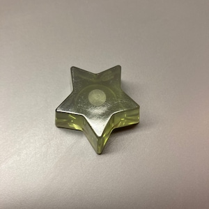 Può includere: Un fermacarte di vetro trasparente a forma di stella con un design circolare smerigliato al centro.