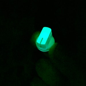 Puede incluir: Una perilla verde brillante con un centro blanco y una fina l&iacute;nea blanca que recorre el centro.