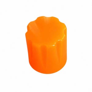 May include: A bright orange cylindrical knob featuring a scalloped top edge with vertical fluted grooves running down the sides. The object has a smooth, glossy finish and a uniform, vibrant colour throughout its entire exterior surface structure.