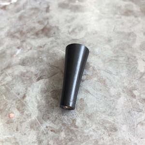 Puede incluir: Pata de mueble de madera negra con un diseño cónico.