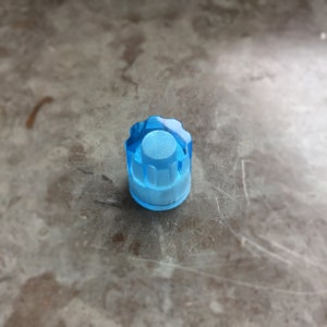 以下が含まれることがあります： 白い中心とリブ模様のある青いプラスチック製のノブ