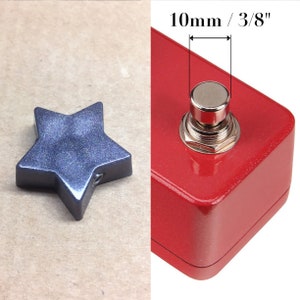 May include: A red metal foot pedal with a silver button. The button is 10mm or 3/8 inches in diameter. The pedal has a sparkly finish.