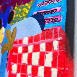 Pode incluir: Pintura abstrata com um padr&atilde;o xadrez vermelho e branco, listras rosa e azuis e cora&ccedil;&otilde;es pretos. A pintura est&aacute; em tela e tem uma superf&iacute;cie texturizada.