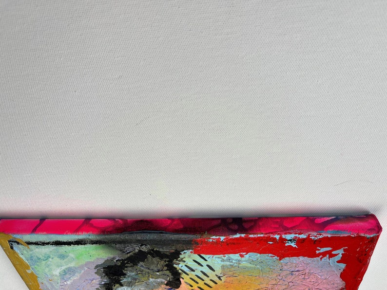May include: Abstract painting on canvas with a mix of bright colors, including pink, red, yellow, blue, and green. The painting has a textured surface and appears to be made with multiple layers of paint.