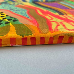 May include: A colorful abstract painting on canvas with a yellow, orange, and red striped border. The painting features a variety of shapes and colors, including green, blue, purple, and pink.