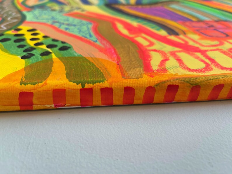 May include: A colorful abstract painting on canvas with a yellow, orange, and red striped border. The painting features a variety of shapes and colors, including green, blue, purple, and pink.