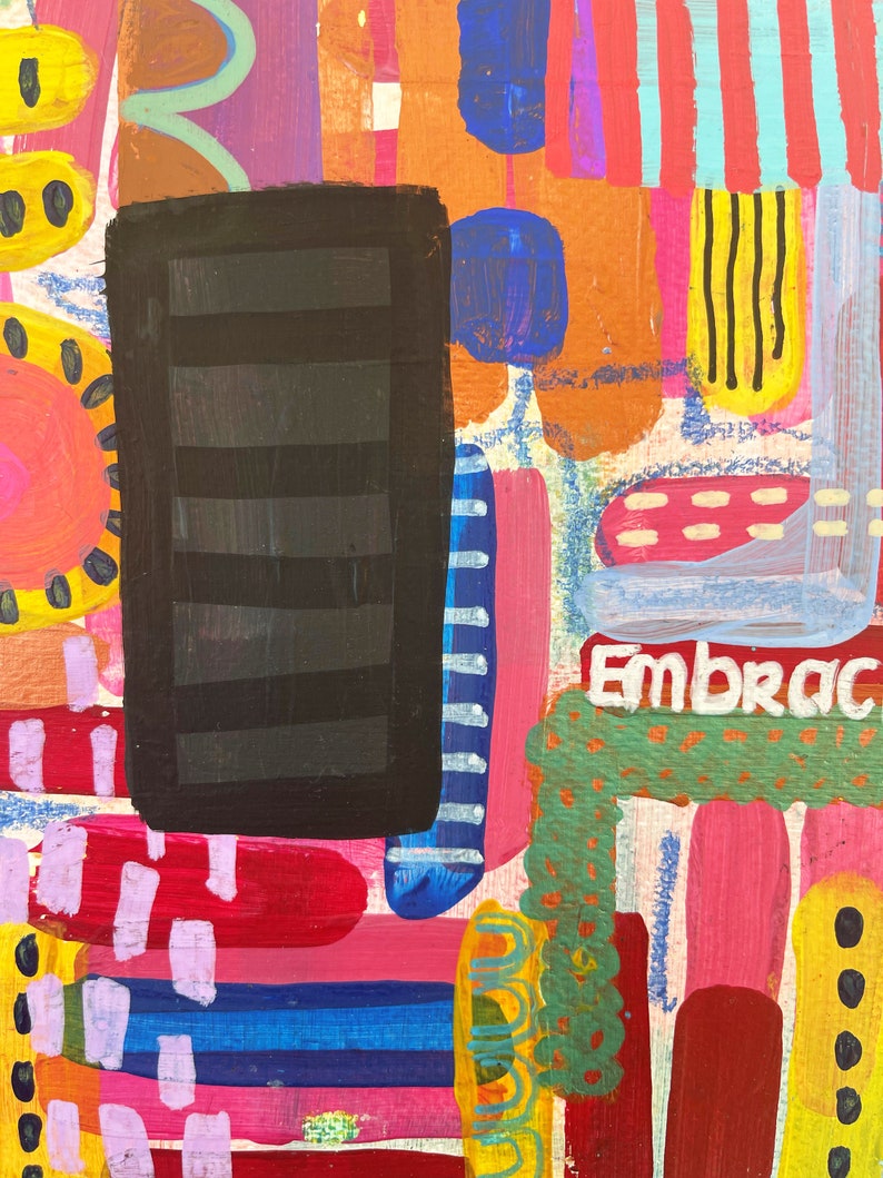 Puede incluir: Pintura abstracta con un rect&aacute;ngulo negro en el centro, rodeado de rayas, puntos y remolinos de colores. La palabra "Embrace" est&aacute; escrita en pintura blanca en la parte inferior de la pintura.