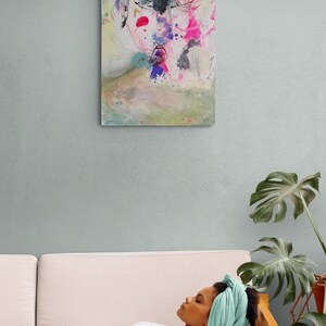 Puede incluir: Pintura abstracta de una cara con salpicaduras de pintura rosa, azul y amarilla sobre un fondo blanco.