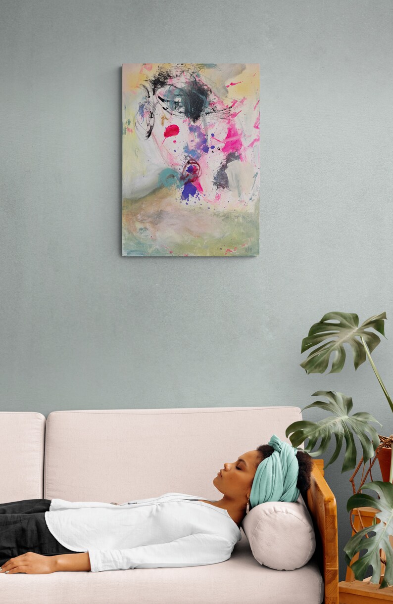 Puede incluir: Pintura abstracta de una cara con salpicaduras de pintura rosa, azul y amarilla sobre un fondo blanco.