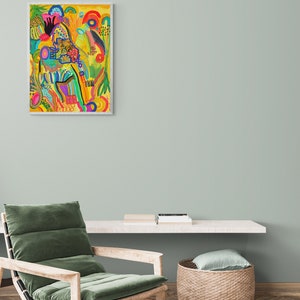 May include: A colorful abstract painting with a yellow background and a variety of shapes and colors, including red, orange, yellow, green, blue, and purple. The painting is framed in a white frame and is hanging on a light green wall.