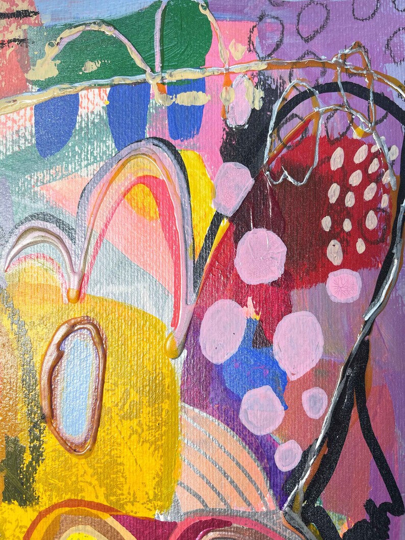 Puede incluir: Pintura abstracta con colores y formas audaces. La pintura presenta un fondo amarillo, naranja y rosa con un dibujo de l&iacute;nea negro y plateado. Tambi&eacute;n hay c&iacute;rculos rosas y azules en toda la pintura.