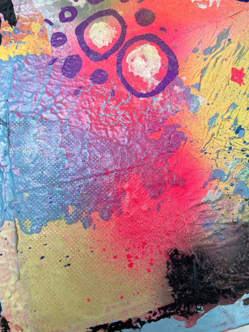 May include: Abstract painting with a colorful background of pink, blue, yellow, and orange. The painting features purple circles and dots.