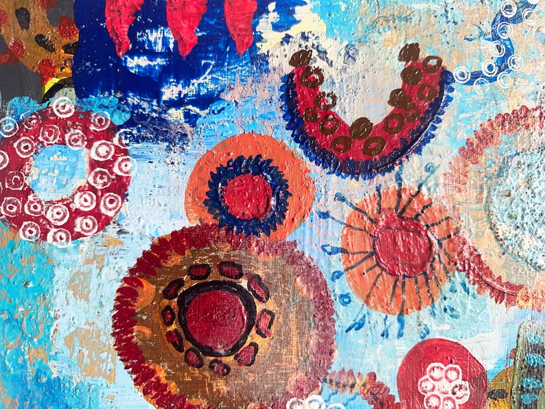 May include: Abstract painting with a blue background and colourful circles with different patterns. The circles are painted in shades of red, orange, brown, and white.