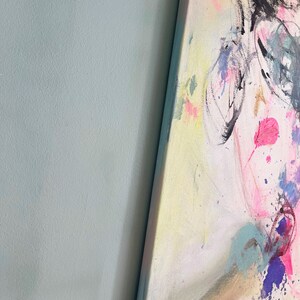 Puede incluir: Pintura abstracta con salpicaduras de pintura rosa, amarilla, azul y morada. La pintura presenta una cara estilizada con l&iacute;neas negras y una boca rosa.