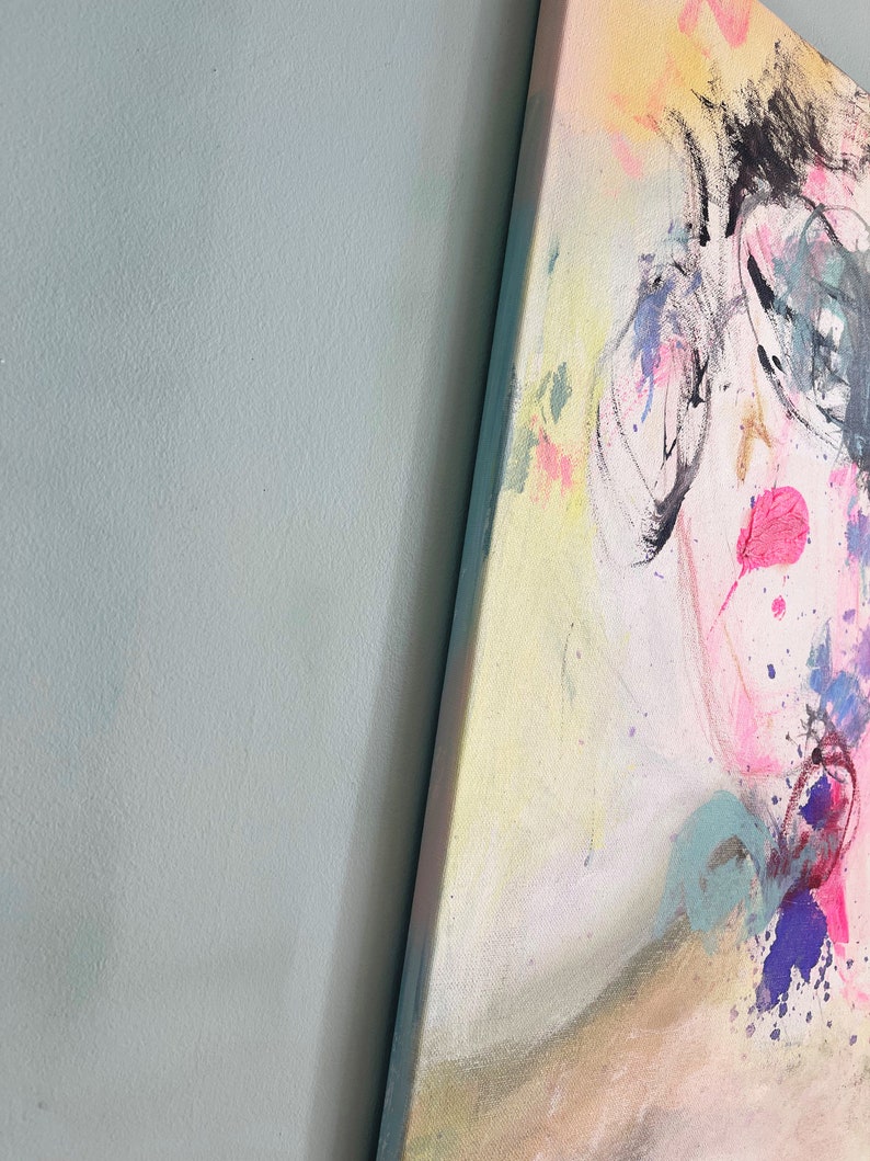 Puede incluir: Pintura abstracta con salpicaduras de pintura rosa, amarilla, azul y morada. La pintura presenta una cara estilizada con l&iacute;neas negras y una boca rosa.