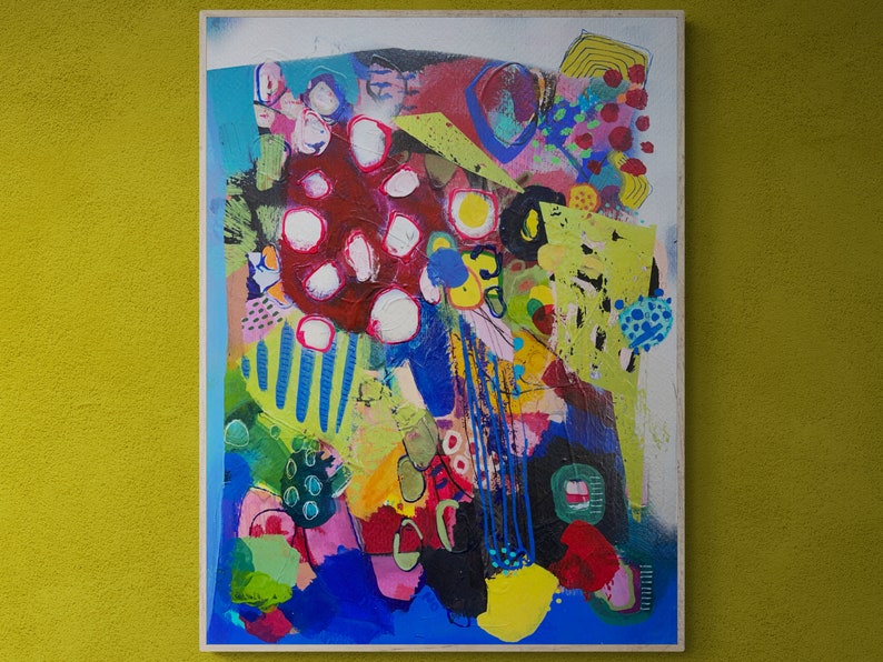 May include: Abstract painting with a colourful, layered design. The painting features a variety of shapes, colours, and textures, including red, blue, green, yellow, and white. The painting is framed and ready to hang.