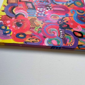 Puede incluir: Pintura abstracta sobre lienzo con fondo amarillo y remolinos, c&iacute;rculos y l&iacute;neas de colores en rosa, rojo, morado, azul y verde.
