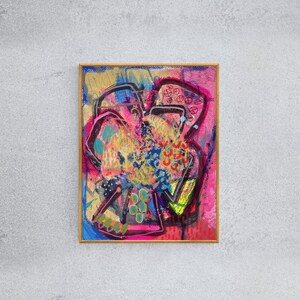 May include: Abstract painting in a gold frame with a pink, blue, yellow, and green color scheme. The painting features a variety of shapes and lines, creating a dynamic and energetic composition.