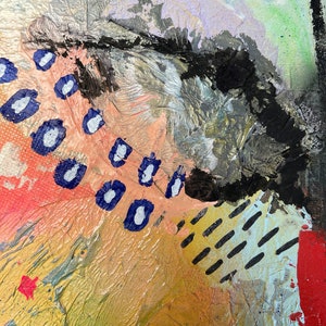 May include: Abstract painting with a mix of textures and colors, including black, white, blue, pink, and gold. The painting features a large black shape in the upper right corner, with a series of blue and white dots scattered across the lower left corner.