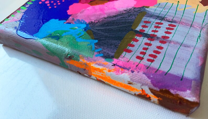 Puede incluir: Pintura abstracta sobre lienzo con un dise&ntilde;o colorido y en capas. La pintura presenta colores brillantes como rosa, azul, verde, naranja y rojo. Los bordes del lienzo son visibles, mostrando el material crudo del lienzo.