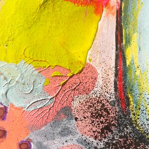 May include: Abstract painting with a yellow, orange, pink, and blue color scheme. The painting has a textured surface and a splattered effect.