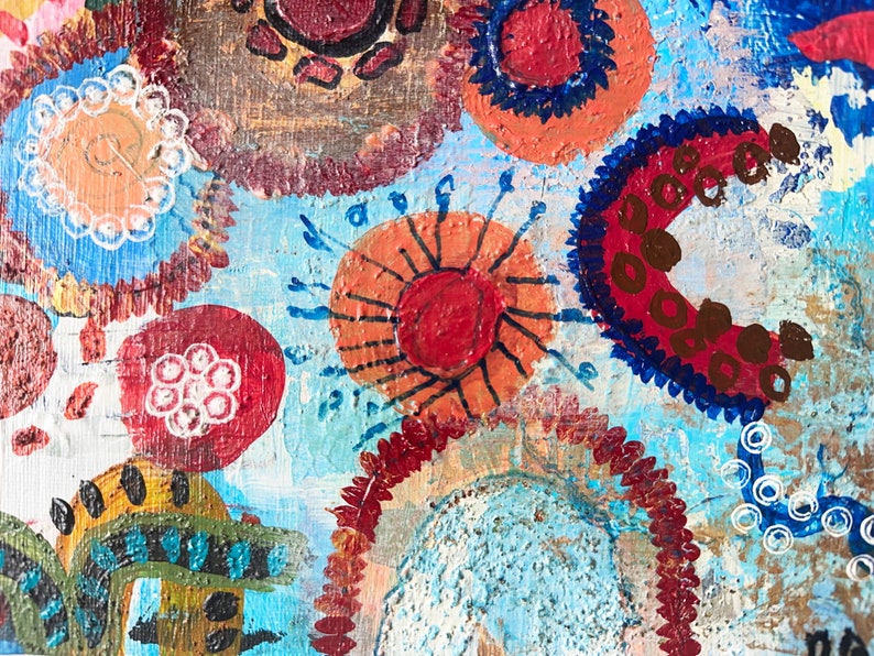 May include: Abstract painting with a blue background and colourful circles, dots, and swirls. The circles are in shades of red, orange, brown, and white.