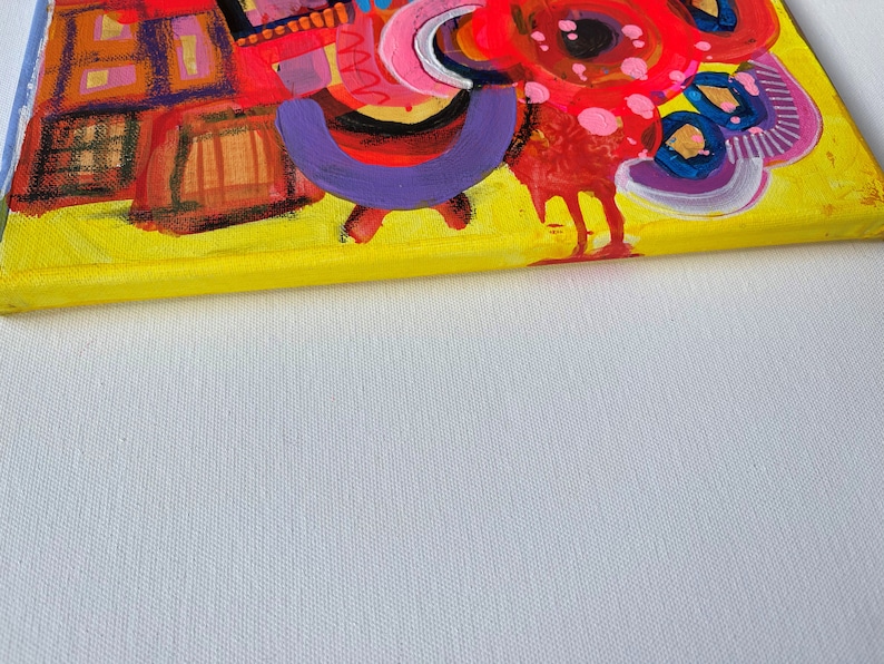 Puede incluir: Pintura abstracta sobre lienzo con fondo amarillo. La pintura presenta una variedad de formas y colores, incluyendo rojo, rosa, morado, azul y negro. La pintura es una obra de arte vibrante y colorida.