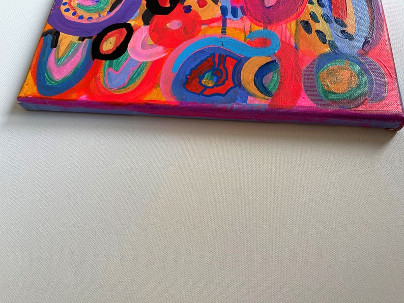 Puede incluir: Pintura abstracta sobre lienzo con un dise&ntilde;o colorido que presenta c&iacute;rculos, espirales y puntos en tonos de rojo, naranja, amarillo, verde, azul, morado y negro.
