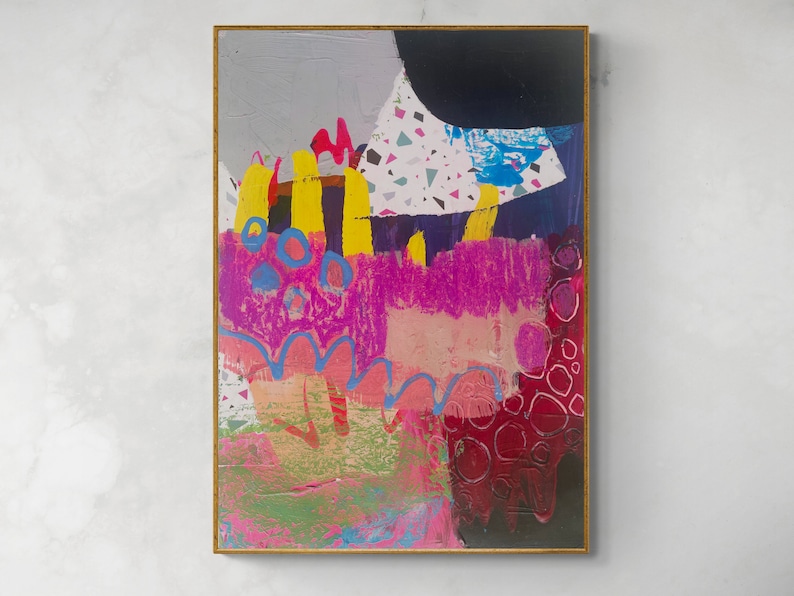 May include: A rectangular painting in a thin gold frame featuring abstract layers of paint. The composition includes vibrant yellow vertical strokes, bright pink textured areas, blue circular outlines, a black shape, and a white section with multicoloured confetti-like flecks.