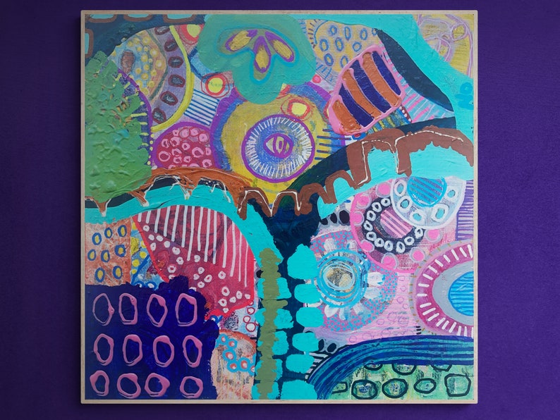 May include: Abstract painting with a colorful, layered design featuring circles, stripes, and dots in shades of pink, blue, green, yellow, and brown. The painting has a textured surface and a modern, abstract style.