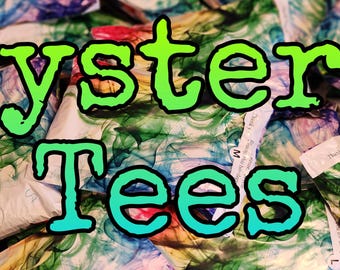 Peut inclure: Un tas de tissus colorés et à motifs enveloppés dans des sacs en papier blanc. Les sacs sont étiquetés "Mystery Tees".