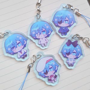 Puede incluir: Cinco colgantes acrílicos estilo anime con un personaje de pelo azul en varios atuendos. Cada colgante tiene un cierre plateado y un cordón azul. El personaje tiene ojos azules y se muestra con un parche en el ojo o vendajes.